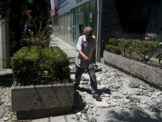 Un hombre camina entre escombros caídos de un edificio en Ciudad de México tras un...