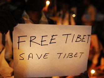 Exiliados tibetanos y activistas de derechos humanos toman parte en una vigilia con velas para...