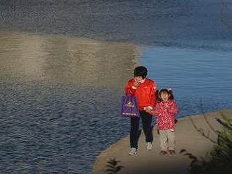 Una madre y su hija caminan por un parque de Pekín el 16 de noviembre de 2013 (AFP, Ed...