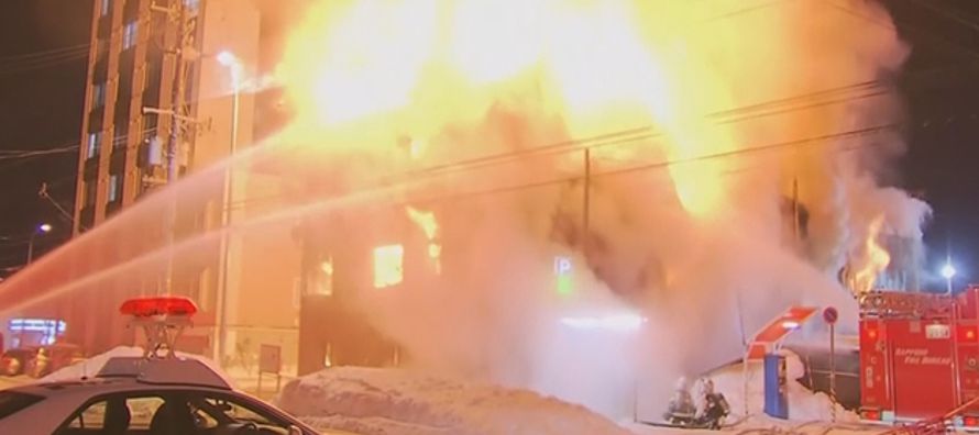 Las imágenes de televisión mostraban un edificio de tres plantas en llamas, con...
