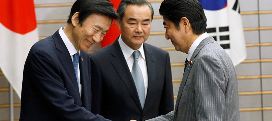 El primer ministro nipón, Shinzo Abe, su homólogo chino, Li Keqiang, y el presidente...