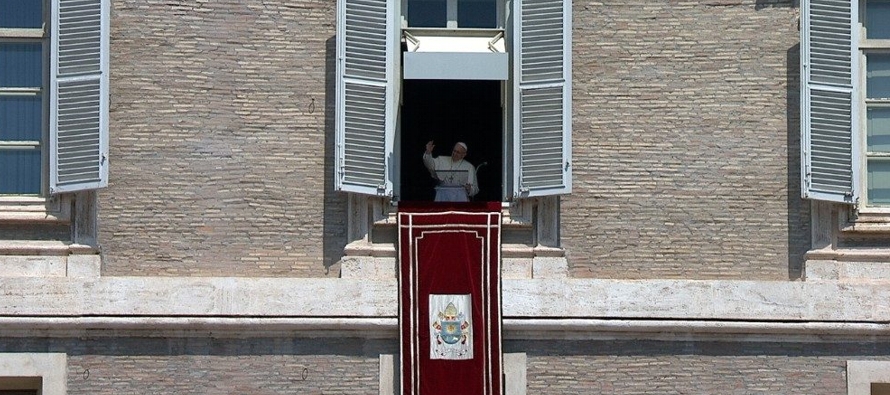 Presidiendo la oración mariana desde una ventana del Palacio Apostólico con vistas a...