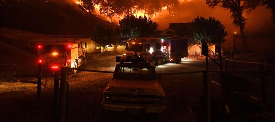 Los bomberos luchaban desesperadamente por impedir que el llamado Holy Fire llegara a las...