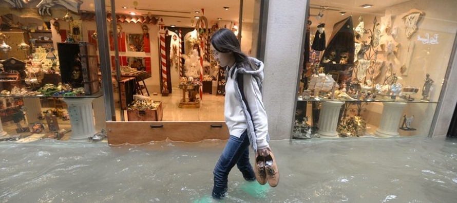 Turistas y vecinos tuvieron que calzar botas altas para recorrer las calles venecianas cuando los...