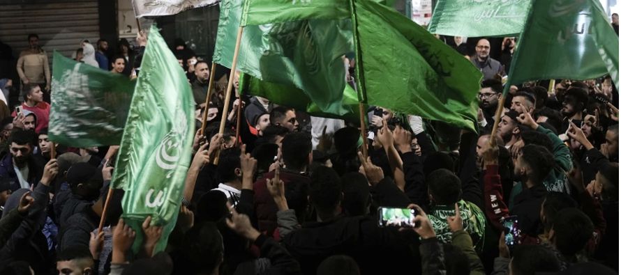 Algunos de los liberados estaban envueltos en banderas palestinas, otros en las banderas verdes de...