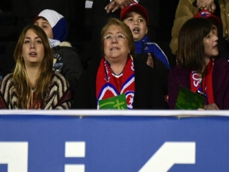 Pero, ataviada con una bufanda de la selección chilena, Bachelet concurrió al estadio...