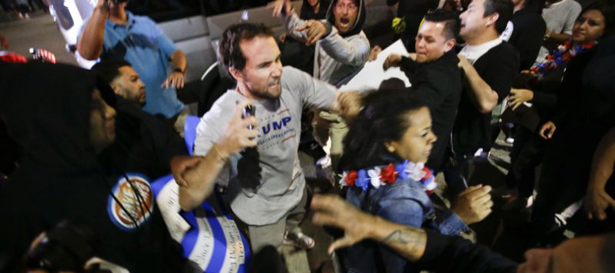 Un partidario del aspirante presidencial republicano Donald Trump choca con manifestantes en las...