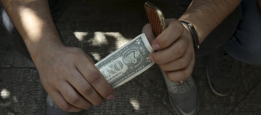En Teherán, las casas de cambio ofrecían 135,000 rial por un dólar, mientras...