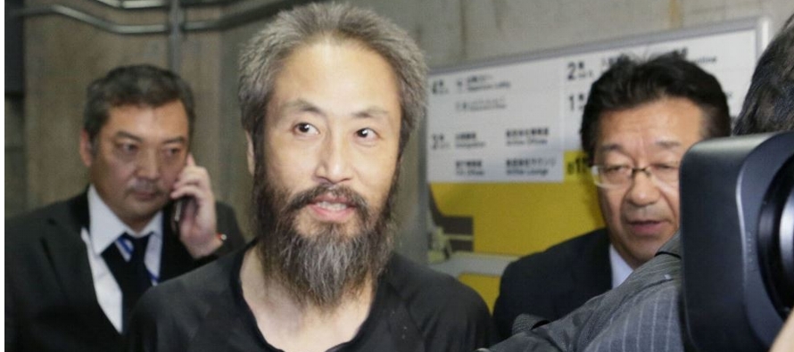 Las autoridades niponas escoltaron a Yasuda, que vestía una camiseta negra, del avión...