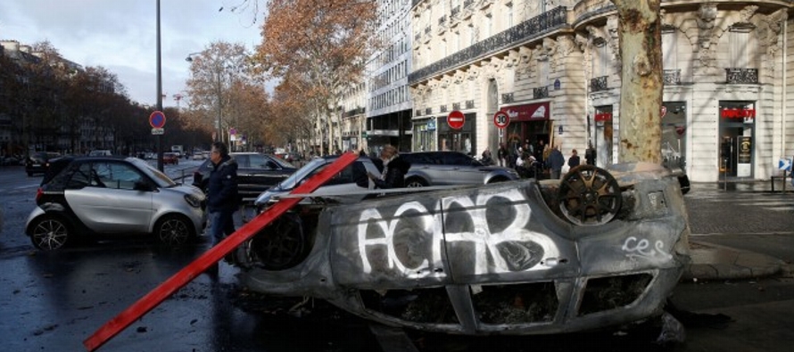 Grupos enmascarados y vestidos de negro corrieron por el centro de París el sábado,...