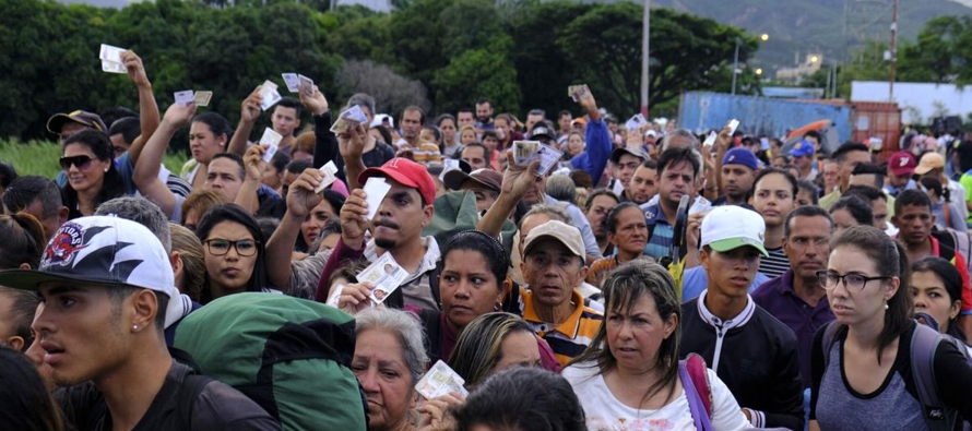 Largas filas de venezolanos, algunos cargando a hijos chicos en hombros, se formaron en dos puentes...