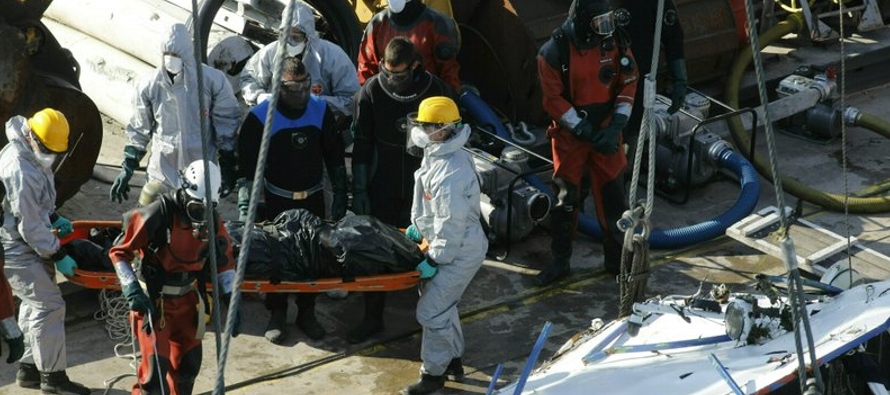Una gran grúa flotante, barcazas y personal de rescate trabajaban desde primera hora de la...