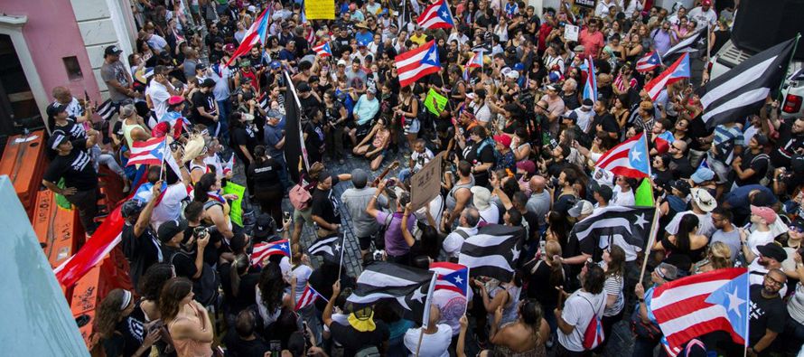 Miles de puertorriqueños marcharon el lunes para exigir la renuncia del gobernador Ricardo...