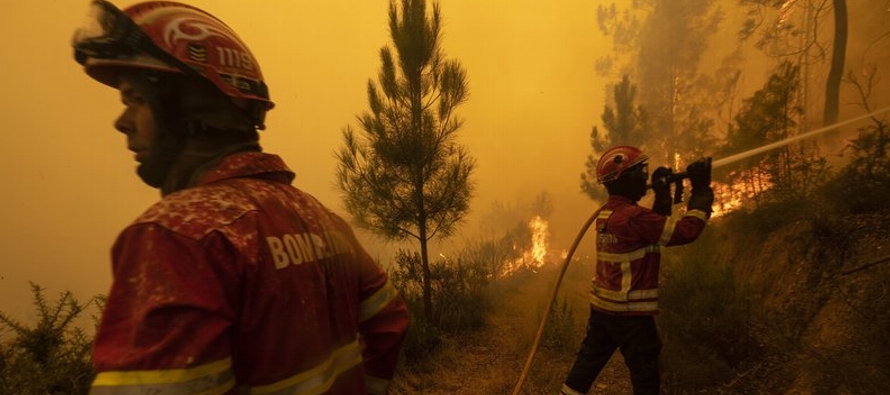 Unos 1,000 bomberos se mantenían alertas ante los restos humeantes e incandescentes, en...