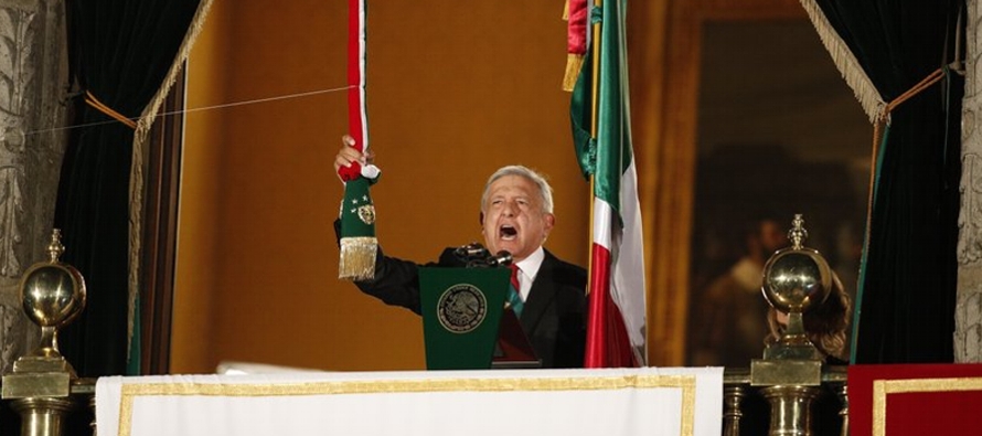 López Obrador, el rostro sobrio, la banda presidencial en el pecho y acompañado de su...
