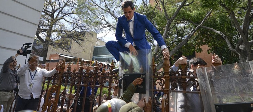 Las imágenes del hombre escalando la cerca de hierro de la Asamblea Nacional,...