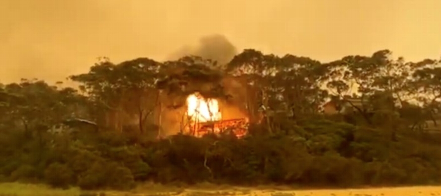 Incendios forestales ardían sin control el sábado cerca de la capital de Australia,...