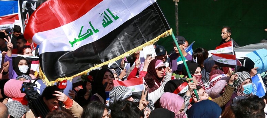 El jueves, cientos de mujeres ondearon banderas iraquíes y carteles en inglés y en...