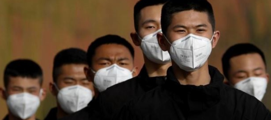 Personal de seguridad con máscaras para contener la propagación de la enfermedad por...