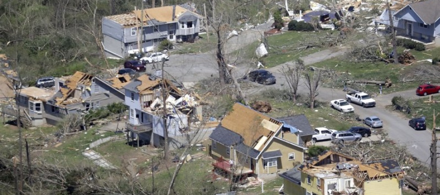 Fotografía de árboles caídos y casas dañadas en una calle en...