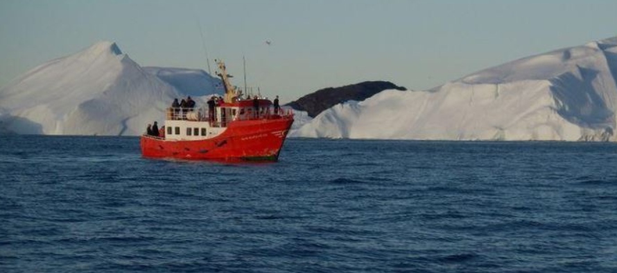 Imagen de archivo de un bote turístico navegando junto a de icebergs cerca de Ilulissat,...