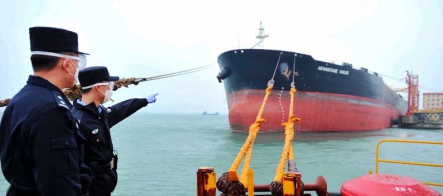Funcionarios chinos supervisan la llegada de un buque cisterna con 230,000 toneladas de...