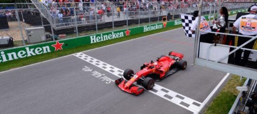 Foto de archivo. Sebastian Vettel de Ferrari pasa la bandera a cuadros para ganar la carrera en el...