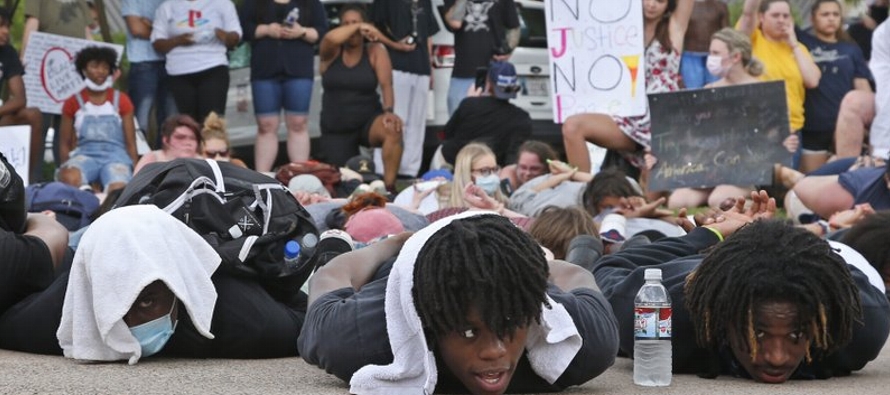 En Boston y Tacoma (estado de Washington), numerosos manifestantes se tendieron en el piso por...