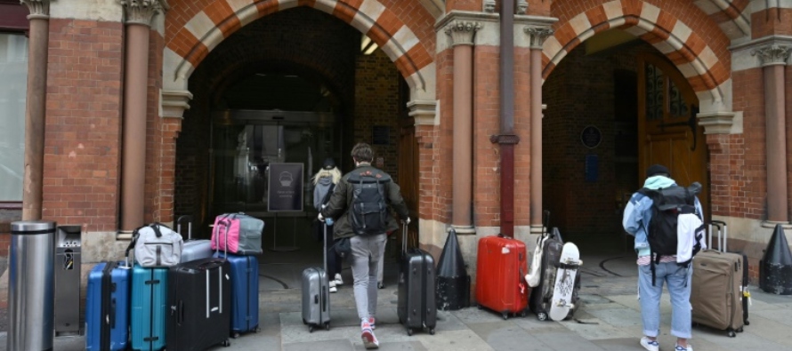 AFP/Archivos / Tolga Akmen Unos pasajeros con mascarilla llegan al aeropuerto de Heathrow, al oeste...