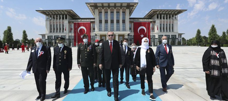 El presidente Recep Tayyip Erdogan, acompañado por civiles que combatieron el intento de...