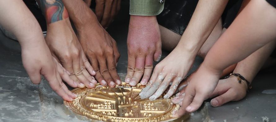La placa redonda de metal dorado fue instalada el domingo en el piso de Sanam Luang, un campo...