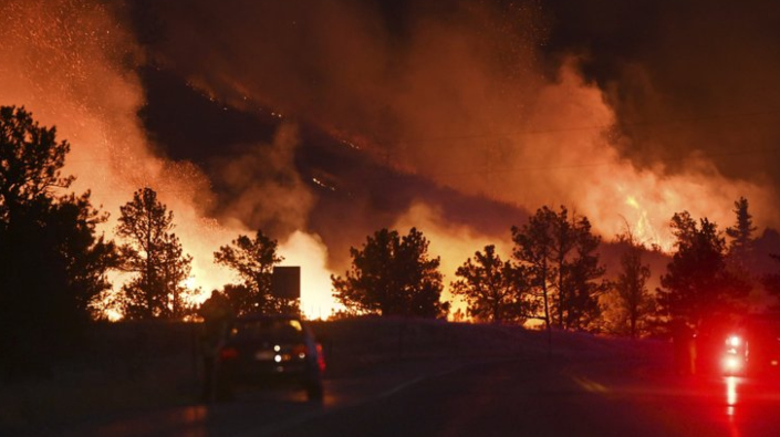 Uno de dos incendios forestales en las Montañas Rocosas avivados por los fuertes vientos se...