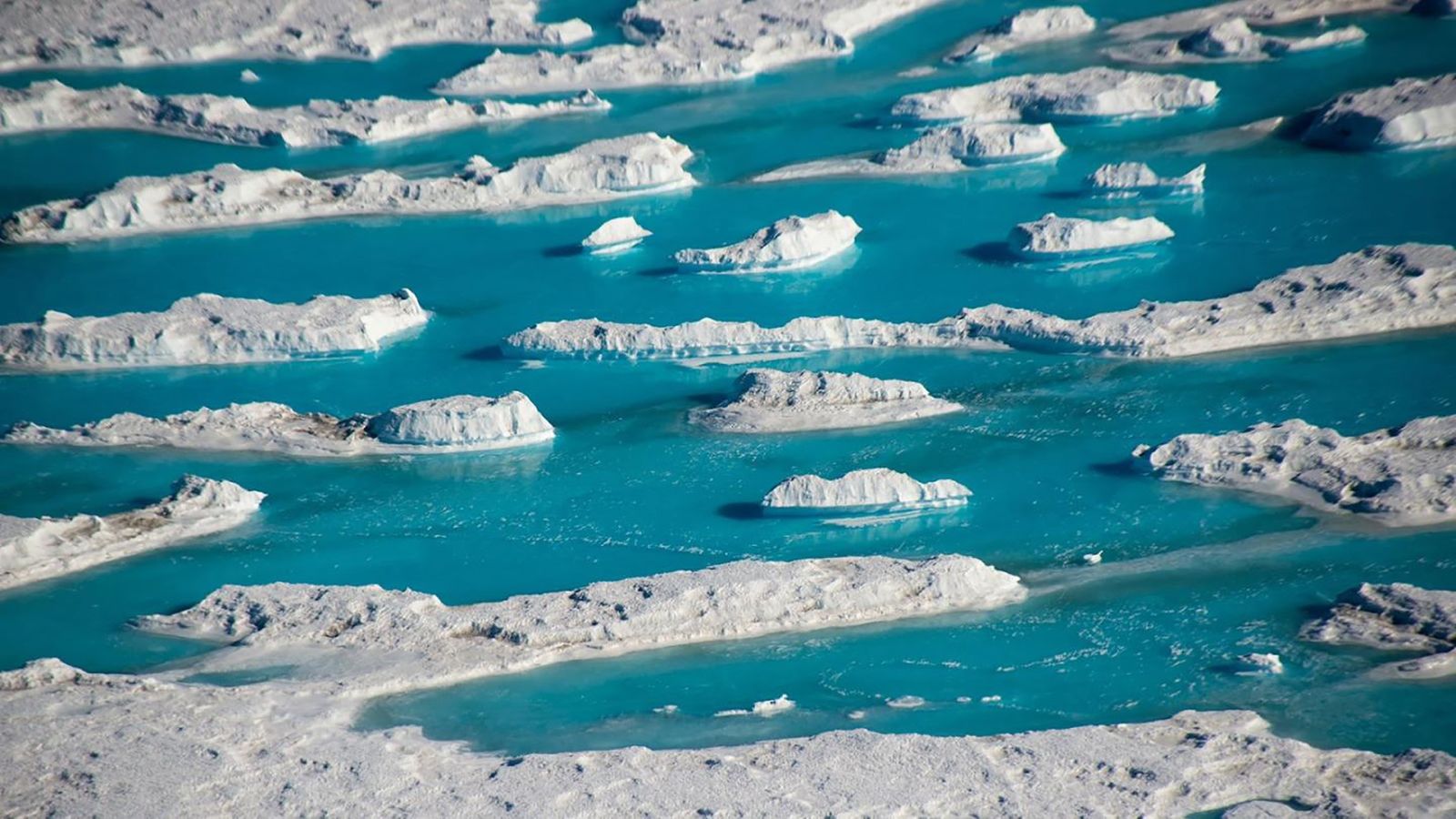 El agua tibia se vierte en el Océano Ártico cubierto de hielo y se esparce por debajo...