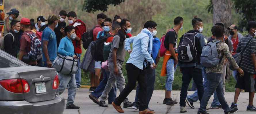 Los migrantes se dispersaron rápidamente a lo largo de la carretera densamente transitada...