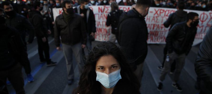 Unas 4,000 personas, con mascarillas para protegerse contra el virus, marcharon por las calles de...