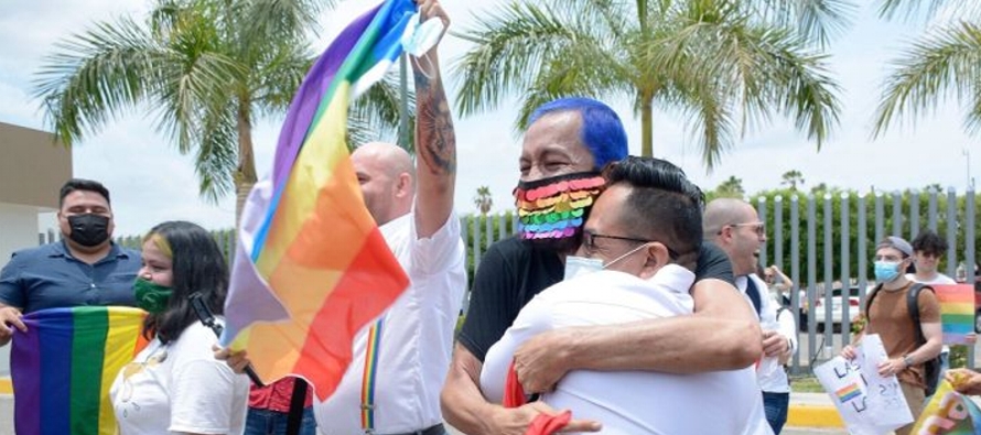 Entre banderas arcoíris y cantando, decenas de personas celebraron la reforma a las puertas...