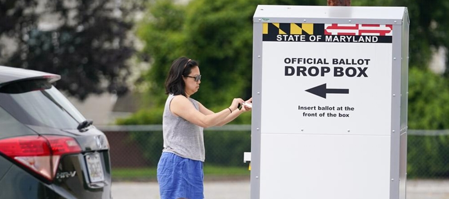 Los funcionarios electorales registran cada papeleta de votación por correo para que los...
