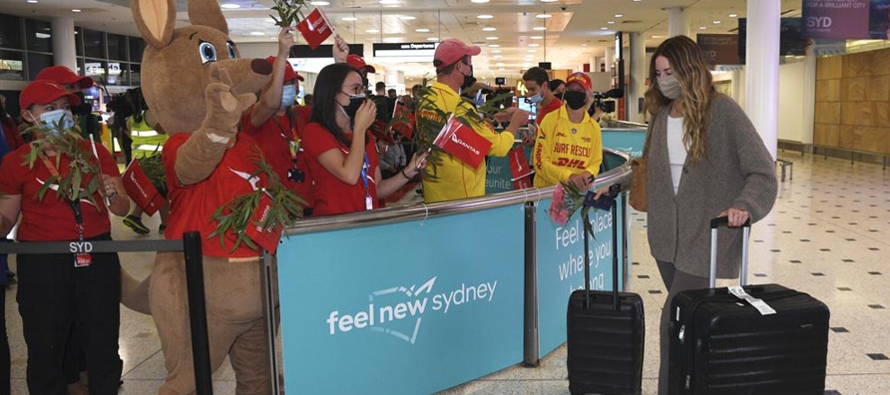 Los viajeros fueron recibidos en el aeropuerto de Sydney por personas entusiastas que alzaban...