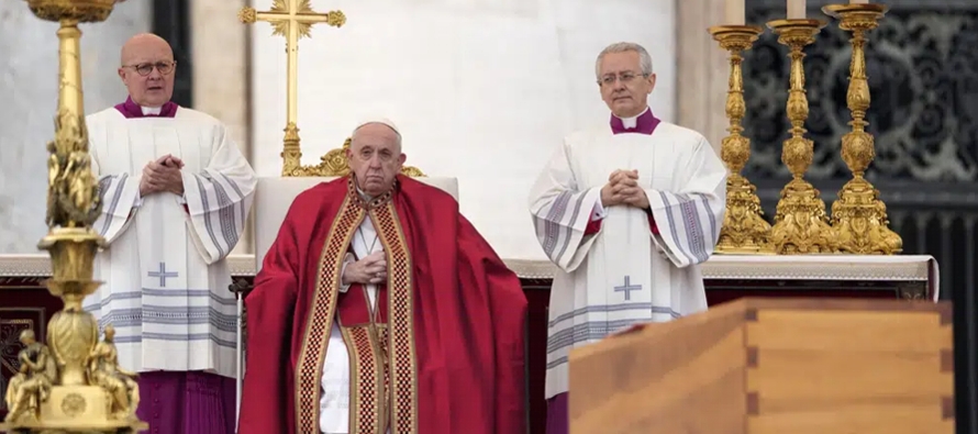 Francisco, ataviado con los ornamentos de color carmesí propios de los funerales papales,...