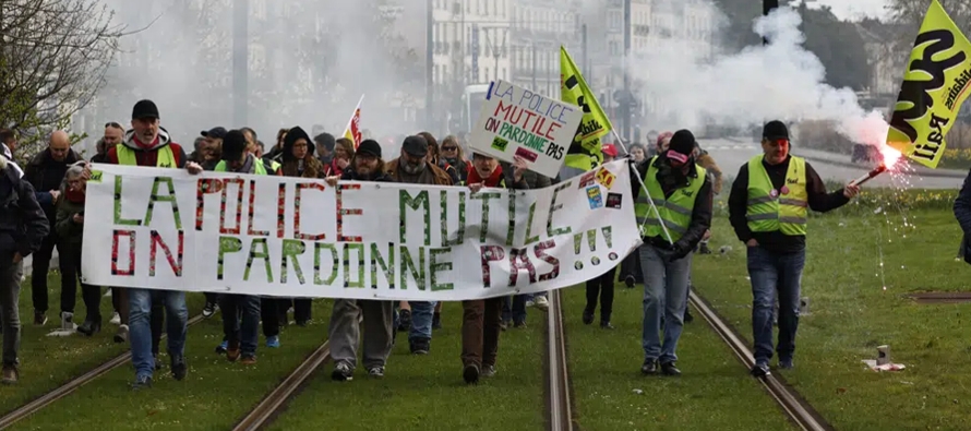 En París, docenas de trabajadores ferroviarios con banderas y bengalas invadieron y...