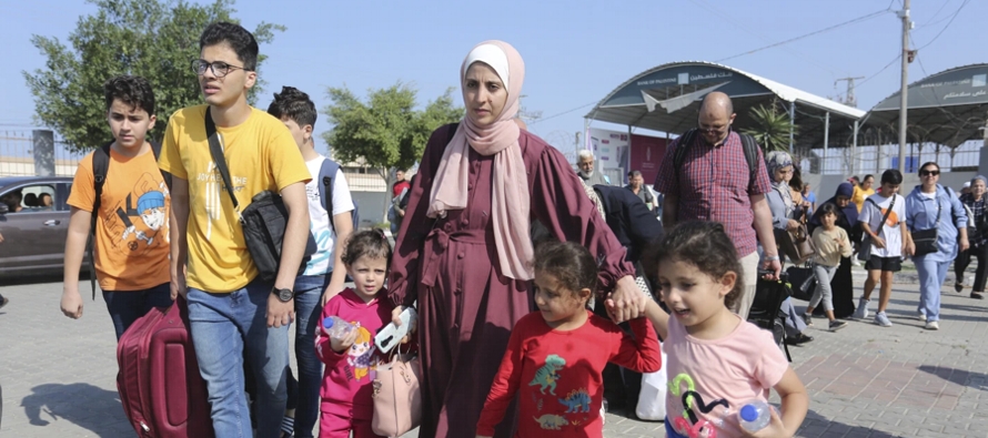 Docenas de personas fueron vistas el miércoles entrando al paso fronterizo de Rafah desde la...