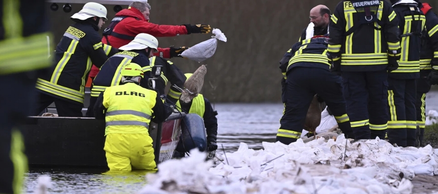 Cientos de voluntarios se unieron a los bomberos para apilar sacos de arena en Uplengen, cerca de...